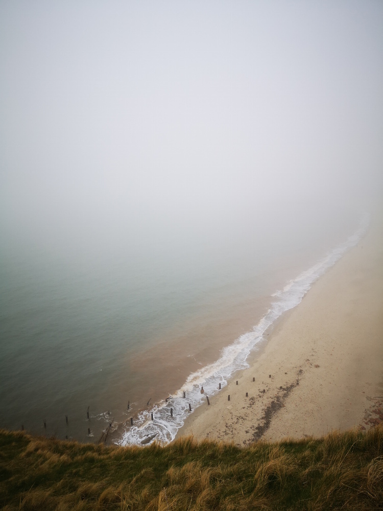 Der Strand wird vom Nebel verschluckt