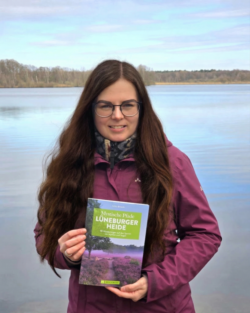 Anika mit dem Buch "Mystische Pfade Lüneburger Heide"